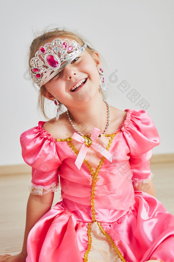 小女孩享受她的角色公主可爱的可爱的年老女孩穿粉红色的公主衣服和头饰坐着地板上小女孩享受她的角色公主可爱的可爱的年老女孩穿粉红色的公主衣服和头饰