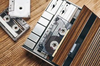 紧凑的盒式磁带磁带和盒式磁带录音机木表格复古的音乐风格音乐聚会，派对古董风格模拟设备立体声声音回来的过去的