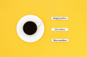 木日历秋天个月9月<strong>10</strong>月11月和杯黑色的咖啡目的是9月黄色的<strong>背景</strong>概念前视图平躺复制空间杯咖啡和日历11月<strong>10</strong>月9月黄色的<strong>背景</strong>