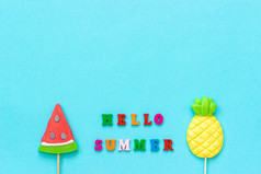 你好夏天色彩斑斓的文本菠萝和西瓜棒棒糖坚持蓝色的纸背景概念假期假期有创意的前视图复制空间模板问候卡明信片你好夏天色彩斑斓的文本菠萝和西瓜棒棒糖坚持蓝色的纸背景概念假期假期有创意的前视图复制空间模板问候