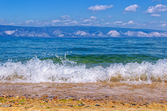 景观与的图像运行波的海岸湖贝加尔湖和山的背景海滩的岛奥尔洪的<strong>纯绿</strong>松石水的湖和的蓝色的天空与云俄罗斯夏天西伯利亚