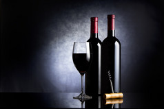 葡萄酒杯和两个瓶酒黑色的背景