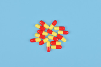 医疗背景与药片黄色的和红色的医疗胶囊蓝色的backgroundTop视图平躺黄色的和红色的医疗胶囊蓝色的背景