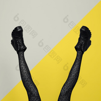 新灰色的女靴子长纤细的女人腿灰色的连裤袜孤立的黄色的和灰色的背景流行艺术概念与重责任靴子新灰色的女靴子长纤细的女人腿灰色的连裤袜孤立的黄色的和灰色的背景