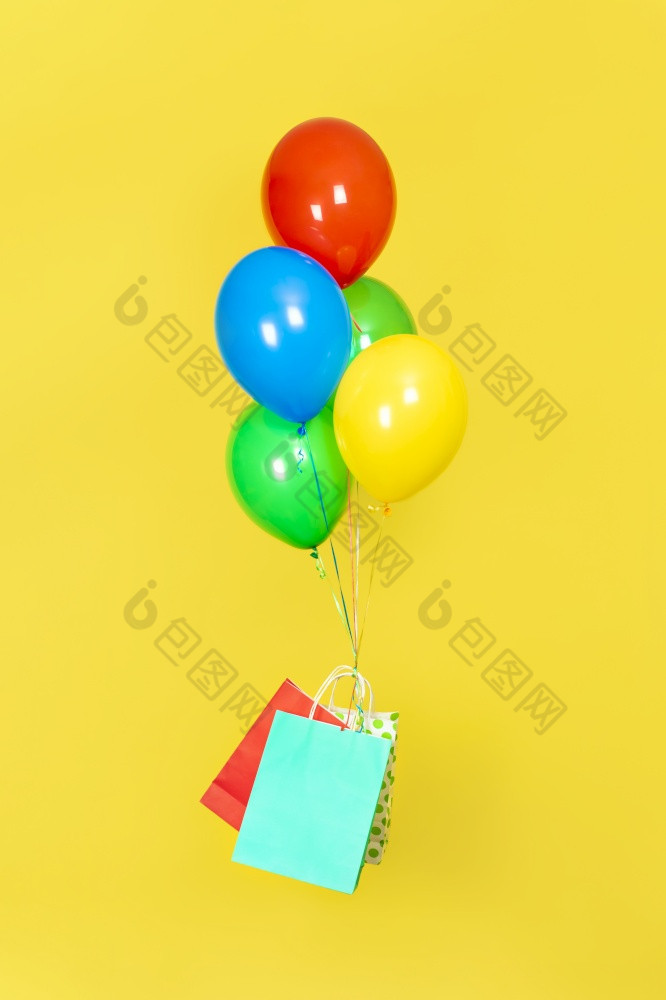 纸袋和群气球飞出售现在交付概念绿色红色的黄色的和蓝色的气球和红色的和蓝色的纸袋飞行孤立的黄色的背景纸袋和群气球飞出售现在交付概念绿色红色的黄色的和蓝色的气球和红色的和蓝色的纸袋飞行孤立的黄色的背景