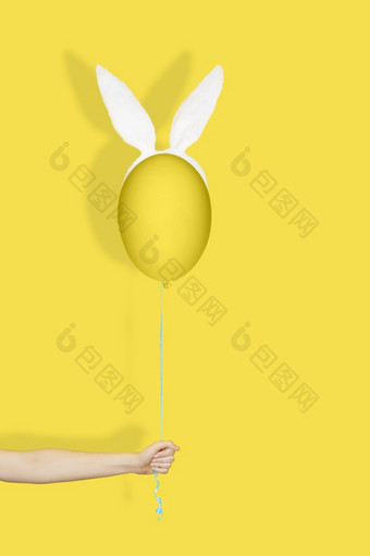 有创意的复活节最小的概念<strong>手</strong>持有黄色的蛋兔子耳朵就像气球字符<strong>串</strong>单色复活节有创意的复活节最小的概念<strong>手</strong>持有黄色的蛋兔子耳朵就像气球字符<strong>串</strong>单色复活节