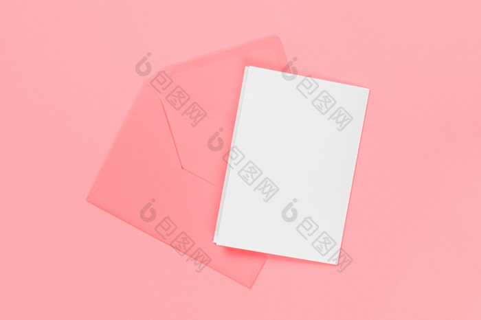 空白白色卡与粉红色的信封孤立的蓝色的背景模板模拟横幅与复制空间空白白色卡与粉红色的信封孤立的蓝色的背景模板模拟横幅与复制空间