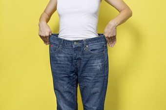 的概念饮食适当的营养重量损失苗条的女人显示宽松的牛仔<strong>裤</strong>和她的损失重量女人白色t恤和超大的牛仔<strong>裤</strong>孤立的黄色的背景的概念饮食适当的营养重量损失苗条的女人显示宽松的牛仔<strong>裤</strong>和她的损失重量女人白色t恤和超大的牛