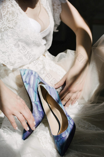 新娘白色婚礼衣服持有婚礼鞋子新娘白色婚礼衣服持有婚礼鞋子她的手