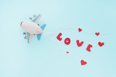 玩具飞机和的明亮的红色的词爱的绳子后面蓝色的背景