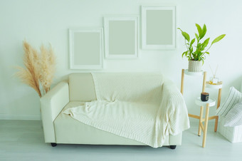 室内<strong>海报</strong>模拟与三个垂直空白色帧灰色的沙发与<strong>针</strong>织毯子室内植物和香味站生活房间与白色墙