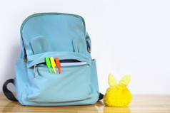 有趣的蓝色的学校袋的形式脸记号笔口袋里和毛茸茸的钥匙链回来学校概念