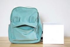 有趣的蓝色的学校袋的形式脸和开放笔记本与空白表回来学校概念复制空间