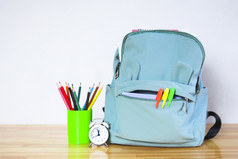 有趣的学校背包与标记彩色的铅笔和报警时钟木表格回来学校概念