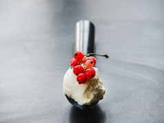 明亮的味道冰奶油和用钉子钉上红色的醋栗孤立的背景特写镜头前视图概念美味的和健康的食物明亮的味道冰奶油和红色的醋栗