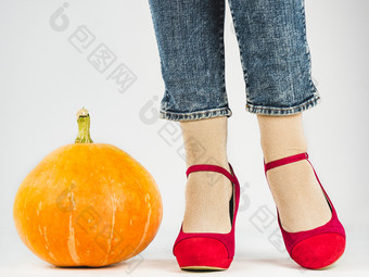 女人rsquo腿时尚鞋子和大成熟的南瓜白色孤立的背景特写镜头概念风格时尚和美女人rsquo腿时尚鞋子和成熟的南瓜