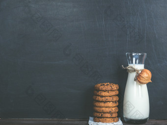 香饼干与块巧克力和壶新鲜的牛奶黑色的背景香饼干和新鲜的牛奶