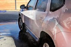 洗车下高压力与水和洗发水特写镜头