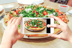 复合图像使披萨照片智能手机女人rsquo手持有移动电话和触碰快门按钮的屏幕