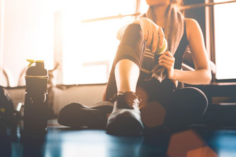 体育运动女人坐着和休息后锻炼锻炼健身健身房与蛋白质摇喝水地板上放松概念强度培训和身体构建主题<strong>温暖</strong>的和很酷的语气