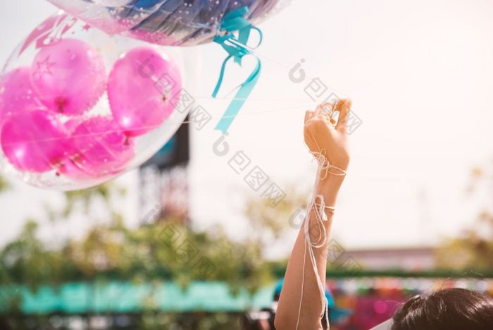 手持有绳子问候气球为特殊的事件生日聚会，派对幸福和庆祝活动聚会，派对概念友谊祝贺和快乐人主题毕业事件主题