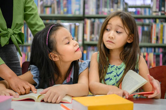 两个可爱的女孩是嫉妒每一个其他而阅读书图书馆而老师教学人生活方式和<strong>教育</strong>年轻的友谊和孩子们的关系学校概念托儿所<strong>主题</strong>