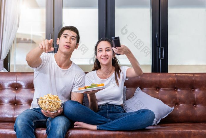 亚洲夫妻看电视在一起沙发他们的首页人和生活方式概念假期和假期概念度蜜月和前婚礼主题快乐家庭活动主题