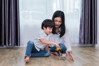 年轻的亚洲妈妈和儿子玩玩具房子妈妈。和儿子概念快乐家庭和首页甜蜜的首页主题学前教育和回来学校主题