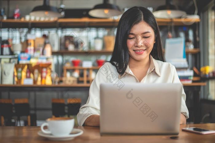 亚洲女自由职业者微笑当使用移动PC咖啡馆业务和成功概念咖啡商店和在户外主题自助餐厅背景