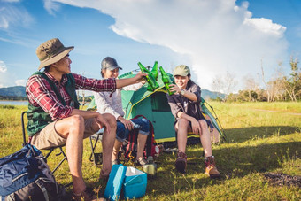 <strong>集团</strong>旅行者野营和做野餐草地与帐篷前景山和湖背景人和生活方式概念在户外活动和休闲主题背包客和徒步旅行者主题