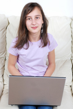 女孩坐着的沙发和使用移动PC