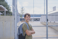 快乐的孩子携带他的背包站前面的学校
