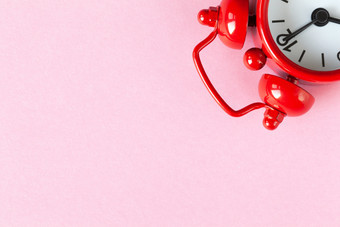 红色的小报警时钟光柔和的粉红色的背景与复制空间平躺最小的风格时间管理概念免费的时间为重要的的事情一个看位于上角落里