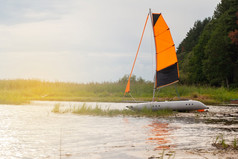 充气航行双体船与提高了帆的河附近的海岸夏天体育概念钓鱼户外娱乐活动旅行假期一边视图太阳耀斑水平