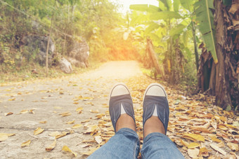 徒步旅行鞋子年轻的女人旅行者坐下来夏天公园焦点蓝色的运动鞋鞋子和牛仔裤通路活跃的活动假期徒步旅行山休息与走道路年轻的旅行者概念
