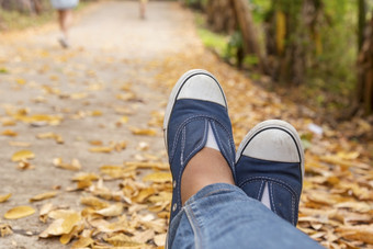 徒步旅行鞋子年轻的女人旅行者坐下来夏天公园焦点蓝色的运动鞋鞋子和牛仔裤通路活跃的活动假期徒步旅行山休息与走道路年轻的旅行者概念