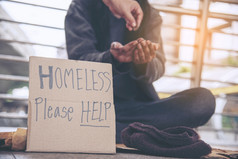 女人帮助手无家可归的人人贫困乞丐男人。持有手问为钱工作和希望帮助无助的脏城市坐着街道绝望的乞丐城市概念