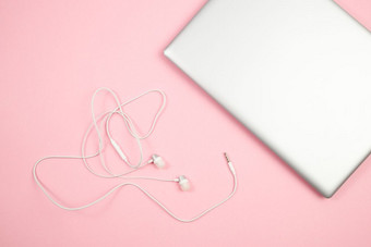 白色《连线》杂志耳机和移动PC粉红色的孤立的背景前视图平躺模型