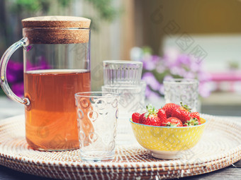 新鲜的自制的柠檬水与草莓在户外的花园表格的夏天色彩斑斓的新鲜的自制的柠檬水与草莓在户外的花园表格的夏天