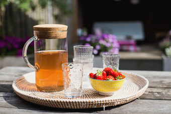 新鲜的自制的<strong>柠檬水</strong>与草莓在户外的花园表格的夏天色彩斑斓的新鲜的自制的<strong>柠檬水</strong>与草莓在户外的花园表格的夏天