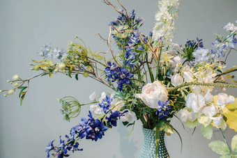 色彩斑斓的假的花花瓶的表格色彩斑斓的绿色和蓝色的背景纹理现代设计美室内装饰色彩斑斓的假的花花瓶的表格色彩斑斓的绿色和蓝色的背景纹理现代设计