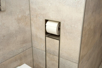 白色卷软厕所。。。纸整齐挂现代铬持有人的墙特写镜头白色卷软厕所。。。纸整齐挂现代铬持有人的墙