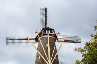 <strong>传统</strong>的荷兰风车的荷兰特写镜头与绿色树<strong>传统</strong>的荷兰风车的荷兰特写镜头