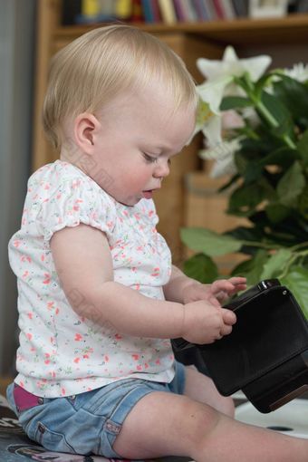 婴儿持有智能手机坐着的生活房间玩生活婴儿持有智能手机坐着的生活房间玩