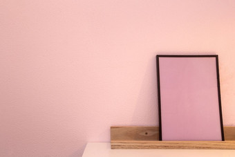 粉红色的空白模拟照片框架的光背景首页室内木架子上附近粉红色的墙特写镜头粉红色的空白模拟照片框架的光背景首页室内木架子上附近粉红色的墙