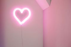 粉红色的心霓虹灯光墙现代室内复古的设计情人节概念特写镜头粉红色的心霓虹灯光墙现代室内复古的设计情人节概念