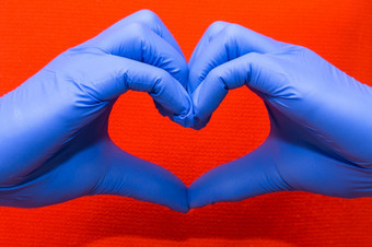 <strong>蓝色</strong>的乳胶手套为<strong>医疗</strong>保护心形式象征支持的医生和护士新冠病毒冠状病毒红色的背景<strong>蓝色</strong>的乳胶手套为<strong>医疗</strong>保护心形式象征支持的医生和护士新冠病毒冠状病毒