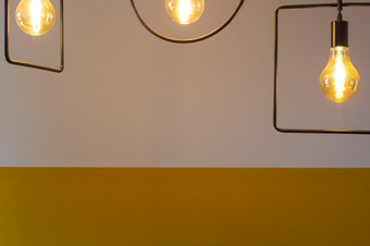 现代设计灯与光灯泡对复古的黄色的墙现代装饰<strong>背景</strong>为<strong>室内</strong>概念特写镜头现代设计灯与光灯泡对复古的黄色的墙现代装饰<strong>背景</strong>为<strong>室内</strong>概念