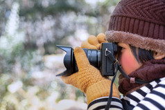 肖像可爱的小女孩羊毛他采取图片与数字相机的天气冷模糊背景摄影概念