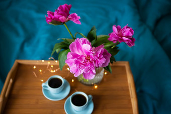美丽的粉红色的牡丹和两个杯咖啡是站<strong>木托盘</strong>床上特写镜头视图从以上美丽的粉红色的牡丹和两个杯咖啡是站<strong>木托盘</strong>床上特写镜头视图从以上